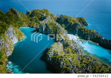 Aerial drone view of Big lagoon surrounded by jagged limestone karst cliffs in morning soft light Aerial drone view of Big lagoon surrounded by jagged limestone karst cliffs in morning soft light 54256412