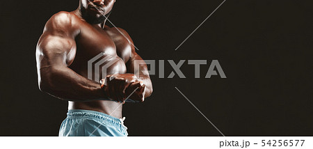 Muscular african man demonstrating strong hands, flexing biceps Muscular african man demonstrating strong hands, flexing biceps 54256577