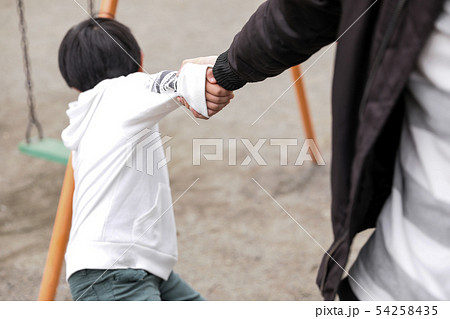 公園で男の子の手を引っ張る男性 お父さん虐待の写真素材