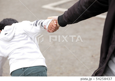 道端で男の子の手を引っ張る男性 お父さん虐待の写真素材
