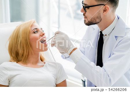 Young dentist examining patient in dental clinic. 54266206
