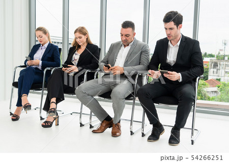 Businesswomen and businessmen using mobile phone. 54266251