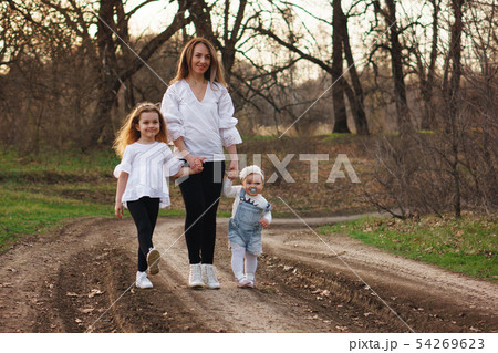 Happy family walks in the spring meadow 54269623