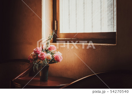plastic flowers in old pot with sunlight window plastic flowers in old pot with sunlight window 54270540