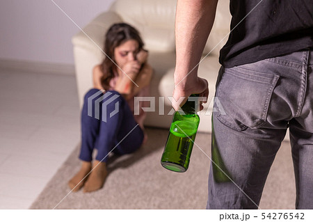 domestic violence, alcoholic and abuse concept - drunk man with bottle abusing his wife lying on the 54276542