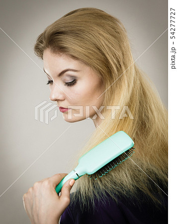 Woman brushing her long hair with brush Woman brushing her long hair with brush 54277727