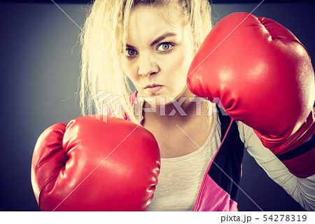 Angry woman wearing boxing gloves 54278319
