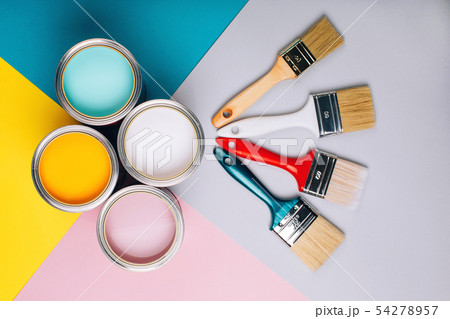 Four open cans of paint with brushes on bright background. 54278957
