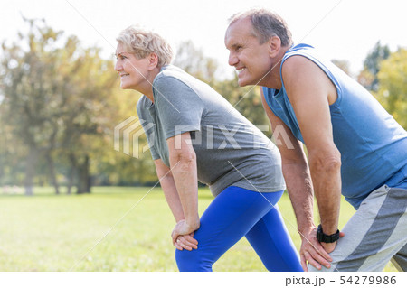 Tilt image of senior couple walking with bicycles Tilt image of senior couple walking with bicycles 54279986