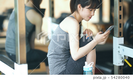 スマホを使う女性　フィットネスジム 54280040