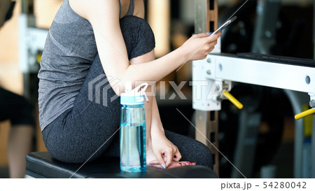 スマホを使う女性 フィットネスジム スマホを使う女性 フィットネスジム 54280042