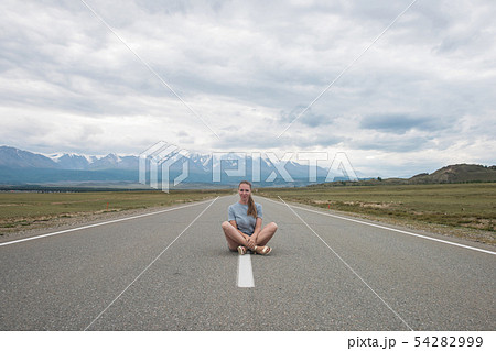 Woman sitting on the road Woman sitting on the road 54282999