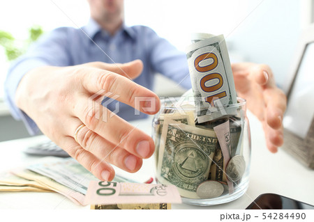 Male hands grabbing big fat jar full of US currency as greed gesture Male hands grabbing big fat jar full of US currency as greed gesture 54284490
