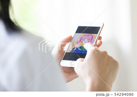 スマホでイラストを描く女子高生の写真素材 スマホでイラストを描く女子高生の写真素材