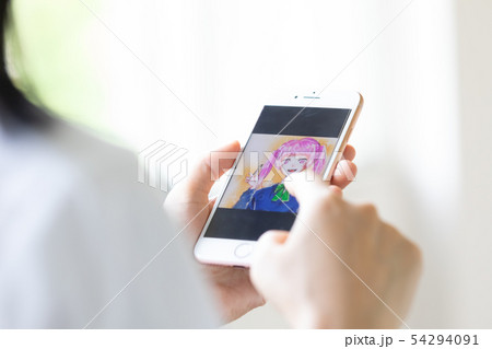 スマホでイラストを描く女子高生の写真素材