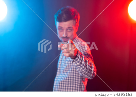 Young handsome bearded hipster man with a beard confidently shows into the camera bearing in mind Young handsome bearded hipster man with a beard confidently shows into the camera bearing in mind 54295162