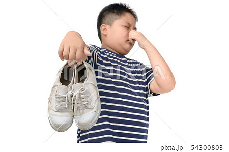 Disgusted fat boy holding a pair of smelly shoes Disgusted fat boy holding a pair of smelly shoes 54300803