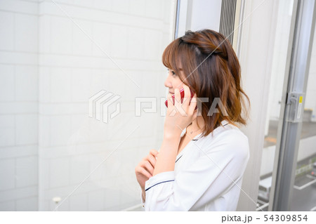 携帯電話で会話をする若い女性 携帯電話で会話をする若い女性 54309854