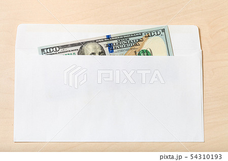 one hundred-dollar bill in open envelope on table 54310193