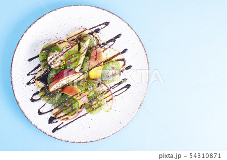 Tasty fruit salad on bright pastel background 54310871
