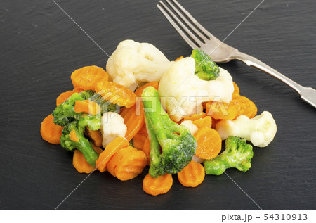 Mix of frozen vegetables on black stone background 54310913