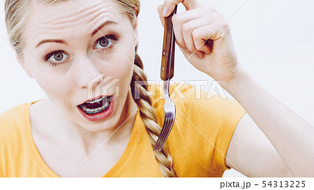Shocked woman holding fork Shocked woman holding fork 54313225