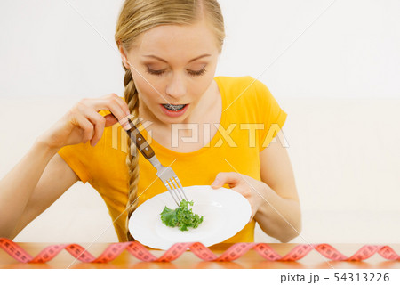 Woman on diet holding plate with lettuce Woman on diet holding plate with lettuce 54313226
