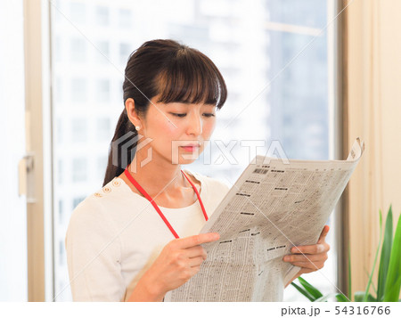 新聞の株式欄を見るビジネスウーマン 54316766