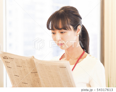 新聞の株式欄を見るビジネスウーマン 54317613