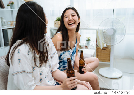 friends in living room relax with electric fan 54318250