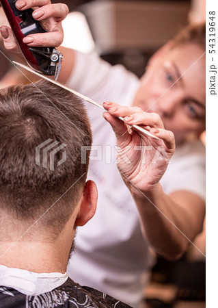 Haircut closeup. Hands holding a hair clipper. Barber, style creation, beauty. Beauty saloon. Haircut closeup. Hands holding a hair clipper. Barber, style creation, beauty. Beauty saloon. 54319648