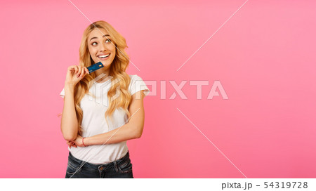 Cheerful Woman Holding Bank Card And Looking Away 54319728