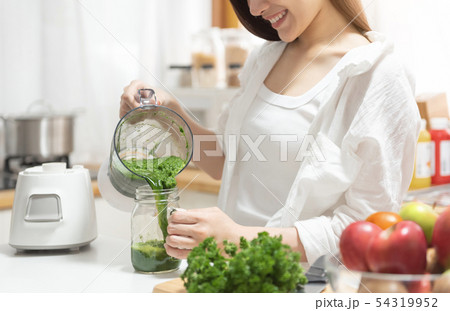 Woman cooking Broccoli smoothie with a blender. Woman cooking Broccoli smoothie with a blender. 54319952