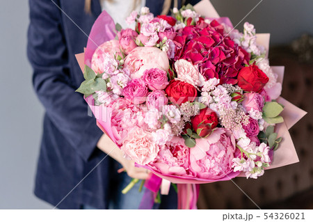 Pink peonies and red hydrangea. Beautiful bouquet of mixed flowers in woman hand. Floral shop 54326021