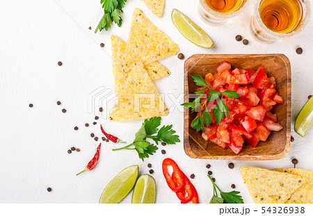 Mexican food salsa, chips and tequila shots with 54326938