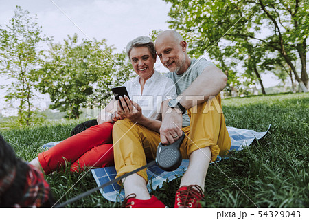 Smiling adult man and woman resting in the park with dogs Smiling adult man and woman resting in the park with dogs 54329043