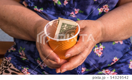 Old woman begs for alms. Closeup of money and 54329542