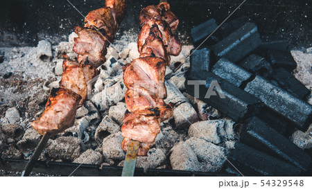 The meat is on charcoal close-up outdoors. Street 54329548