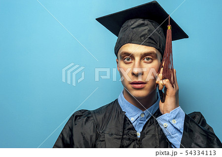 Portrait of Male student graduate on blue background Portrait of Male student graduate on blue background 54334113