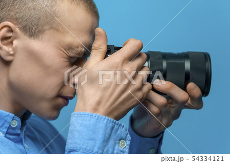 Male photographer examining his new camera 54334121