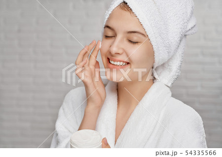 Young woman applying on face cream for hydrating of skin. Young woman applying on face cream for hydrating of skin. 54335566