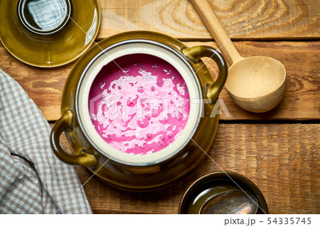 Old vase with  cold beetroot soup and spoon on rustic wooden table 54335745