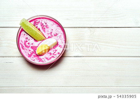 Bowl with cold beetroot soup with egg and cucumber on white table 54335905