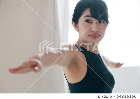 ヨガをする若い女性　日本人　英雄のポーズ　ホットヨガ 54336166