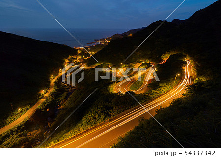 Aerial view of cars driving on curved, zigzag road Aerial view of cars driving on curved, zigzag road 54337342