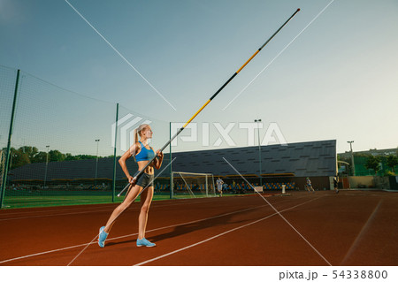 Female high jumper training at the stadium in sunny day Female high jumper training at the stadium in sunny day 54338800