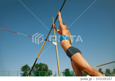 Female high jumper training at the stadium in sunny day 54339107