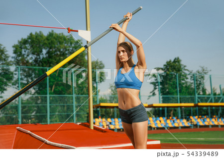 Female high jumper training at the stadium in sunny day 54339489