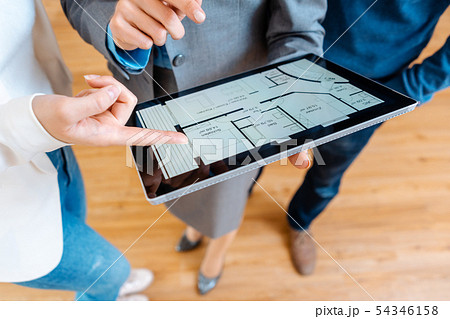 Realtor explaining floor plan to couple buying a house 54346158