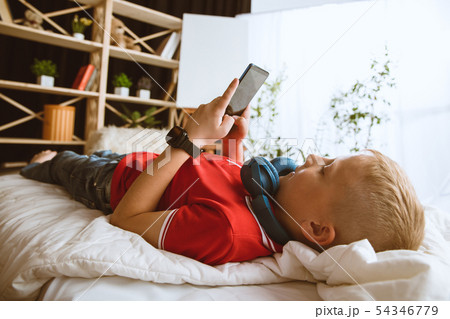 Little boy using different gadgets at home 54346779